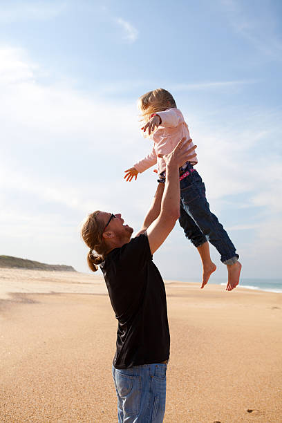 istock Father throwing daughter in air at the beach 177773680