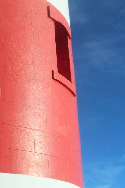 istock Window in a red and white striped lighthouse, against a blue sky 1777747441