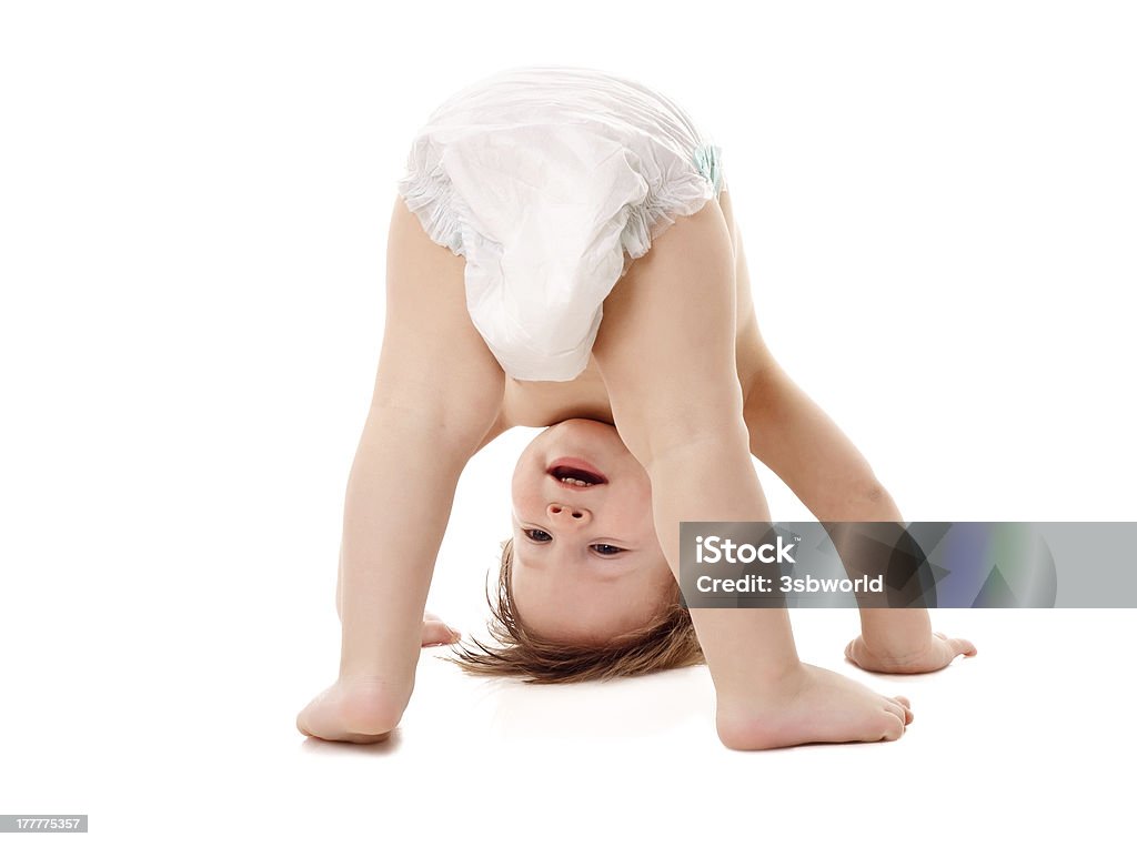 Bambino nel pannolino in piedi sulla sua testa - Foto stock royalty-free di Bebé