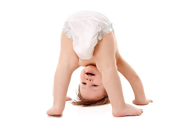 Baby in a diaper standing on his head Funny playing baby standing on his head, isolated on white acrobatic activity photos stock pictures, royalty-free photos & images