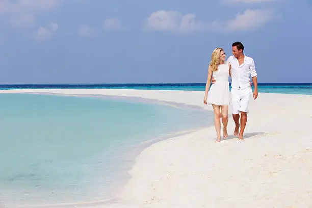 Photo of Romantic Couple Walking On Beautiful Beach