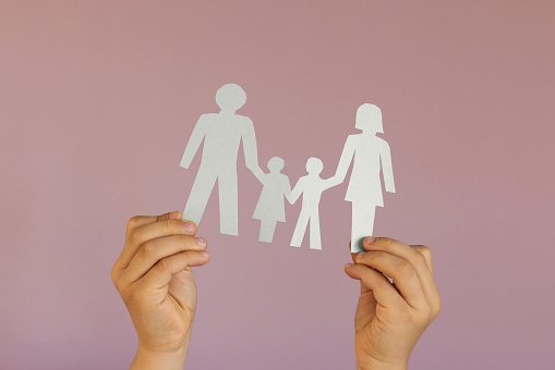 family with two children, family concept, child hands holding paper family