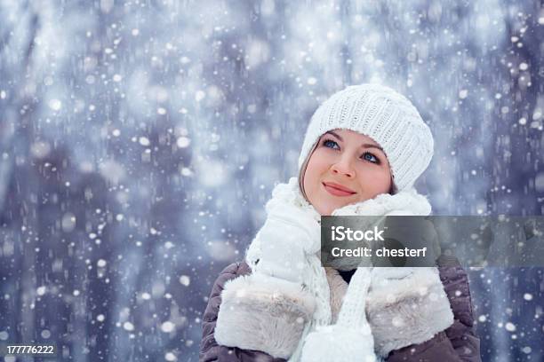 Beautiful Woman Walking Outdoors Under Snowfall Stock Photo - Download Image Now - Adult, Backgrounds, Blond Hair