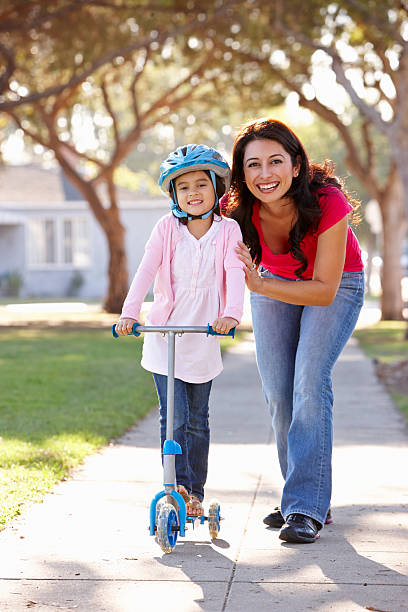 istock Mother Teaching Daughter To Ride Scooter 177777105