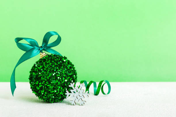 istock Christmas ball on colored background. decoration bauble with ribbon bow with copy space 1777771684