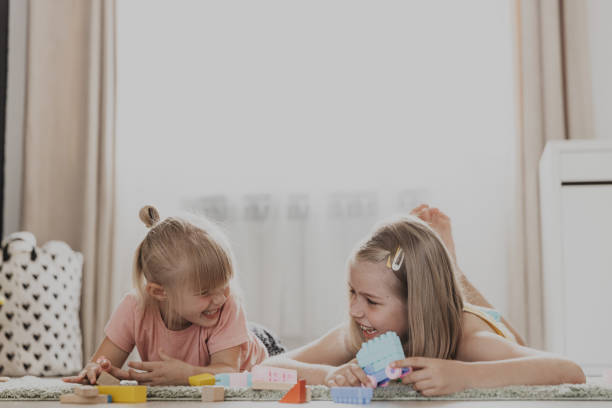 istock Children playing with toy building blocks on the floor at home or kindergarten 1777775607