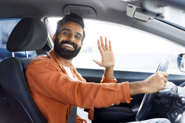 istock Cheerful Indian Man Gesturing Hi From Driver's Seat In Auto 1777777826