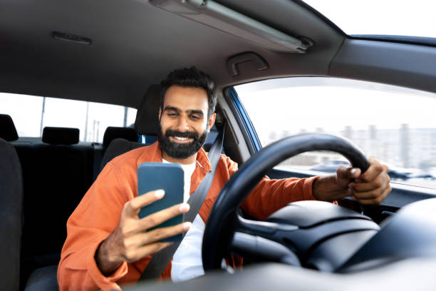 istock Cheerful arab driver man texting on smartphone while driving car 1777779080