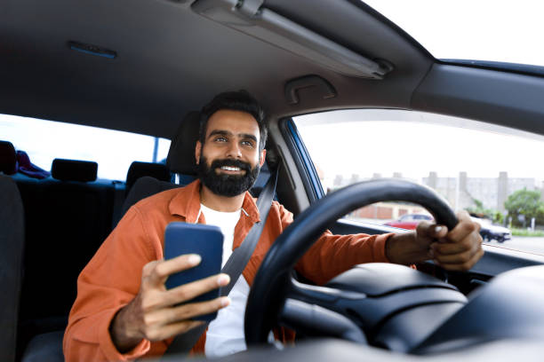istock Happy arabic driver man holding smartphone using app in car 1777779663