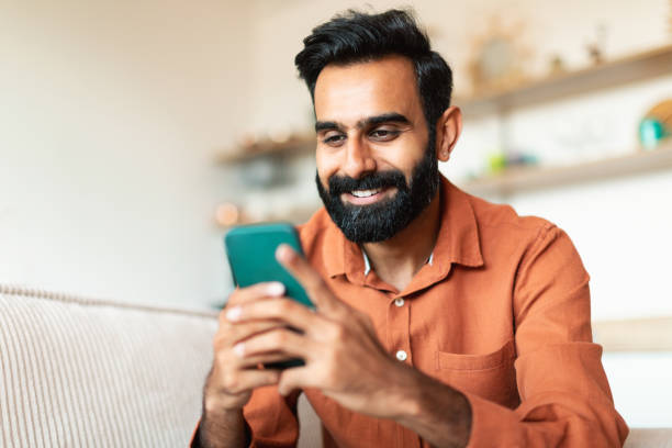 istock Happy arab guy sitting with smartphone in hands at home 1777780228