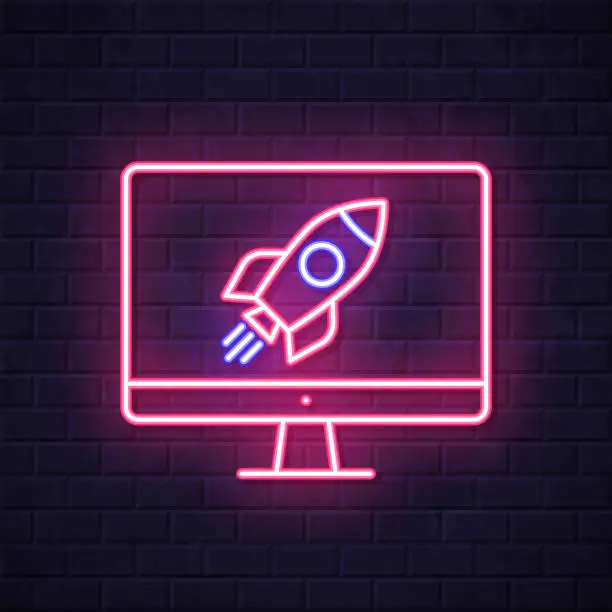 Vector illustration of Desktop computer with rocket. Glowing neon icon on brick wall background