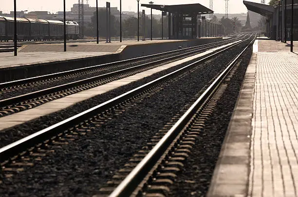 Railway station platforms and rails at sunset