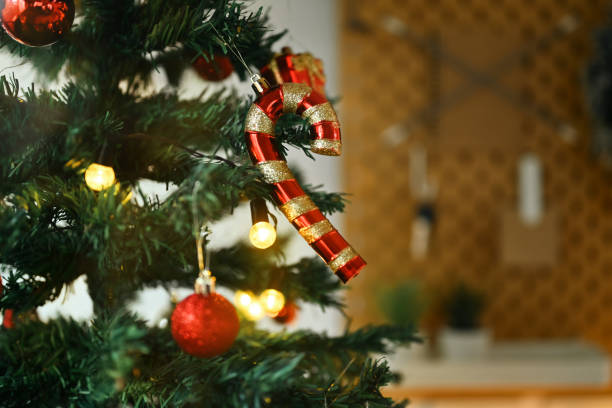 istock Christmas tree branch decorated with candy cane and baubles with blurred shiny lights on background 1777810839