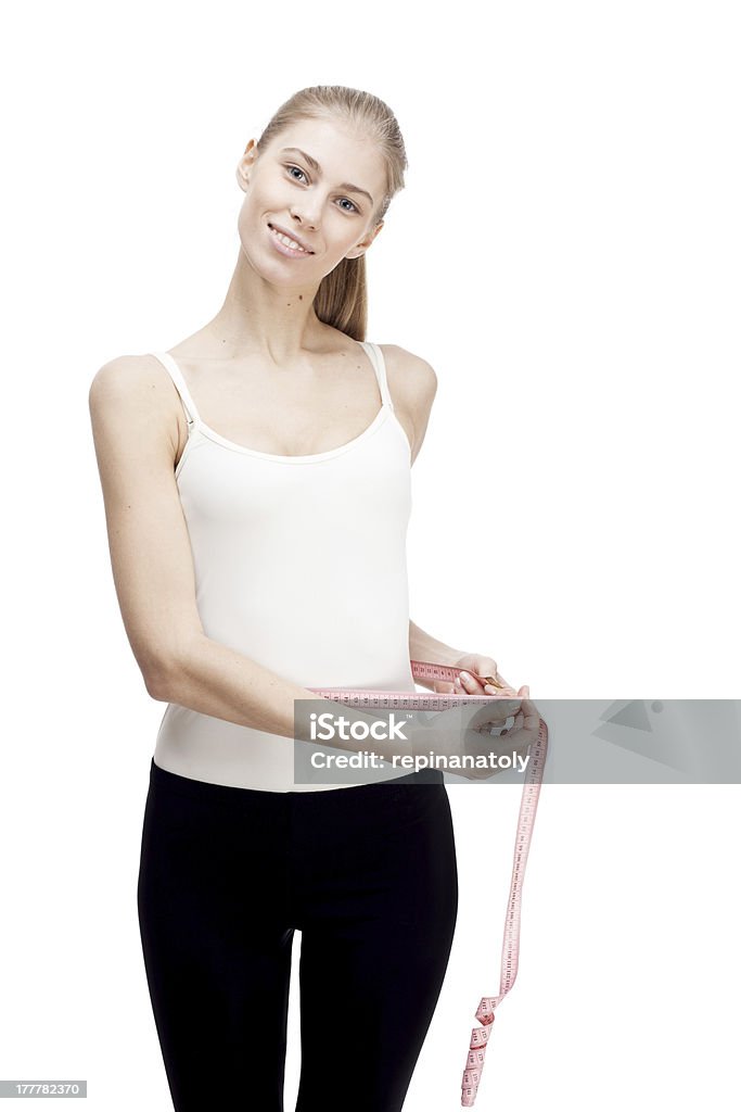 Młoda blond kobieta pomiar talii na białym tle - Zbiór zdjęć royalty-free (25-29 lat)