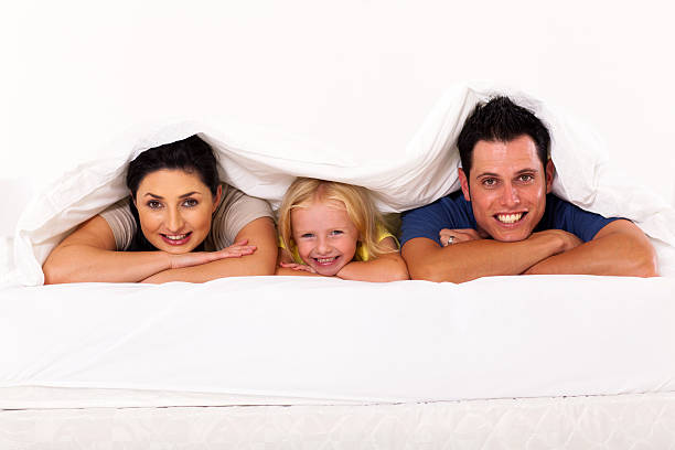 istock happy young family lying under duvet 177782696