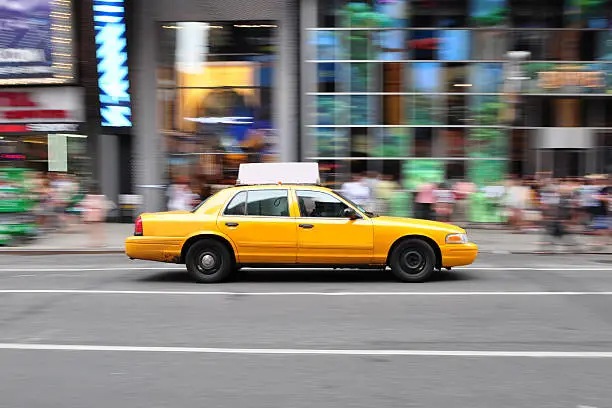 Panning shot of a New York city taxi cab at Times Square in New York, USA.