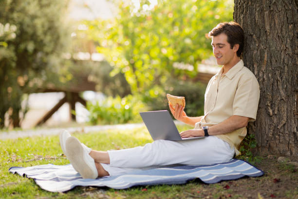 istock Happy millennial man freelancer working at public park, having snack 1777829194