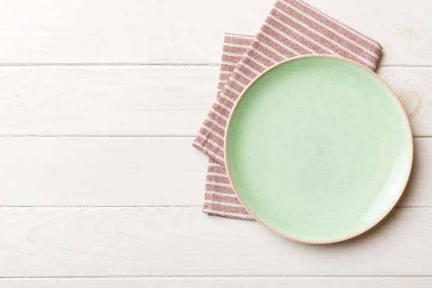 istock Top view on colored background empty round green plate on tablecloth for food. Empty dish on napkin with space for your design 1777830438