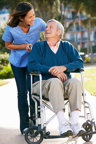 istock A nurse pushing a senior man in a wheelchair 177783600