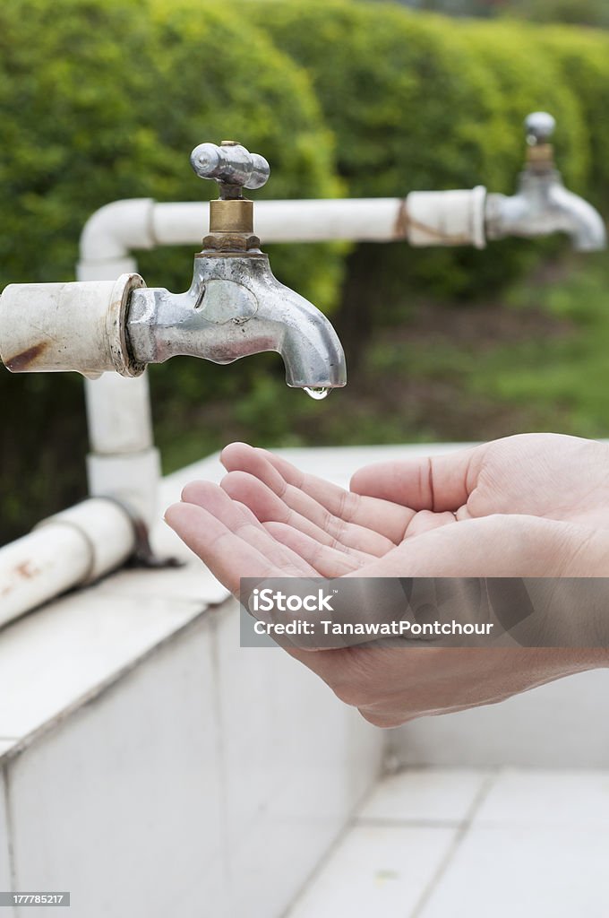 Mão Aguarde escorrendo água da torneira antiga - Foto de stock de Braço humano royalty-free