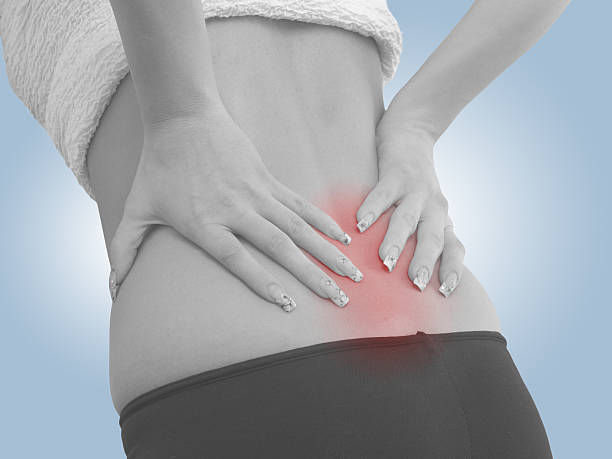 女性の背中の痛みに - backache human spine lumbosacral region blue ストックフォトと画像