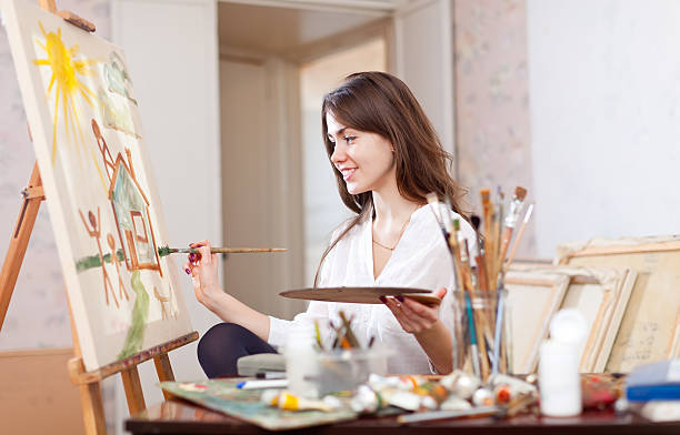 istock woman paints landscape on canvas 177786062