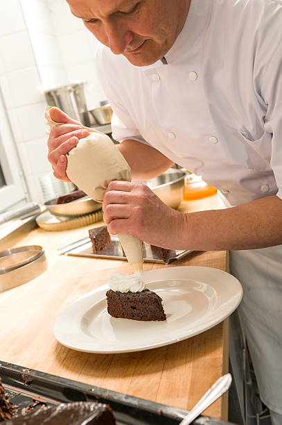 chef Decorando bolos com glacê - foto de acervo