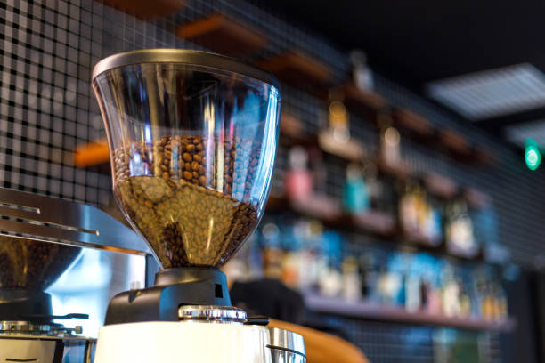 A close-up of an electronic coffee grinder in a modern cafe, with ample space around it for text or other elements.