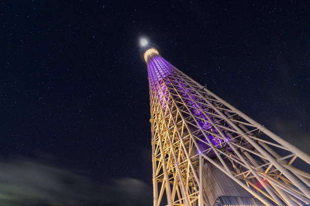 A night view of the impressive Tokyo Sky Tree from the base at night with stars.