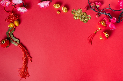 Chinese New Year background with traditional decorations on red background, top view.