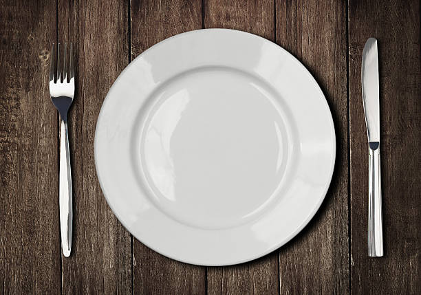 istock white plate, knife and fork on old wooden table 177787995