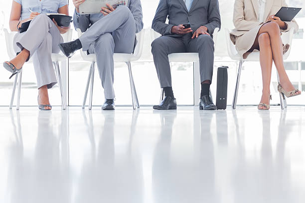 Group of business people waiting Group of business people waiting together in a waiting room cross legged stock pictures, royalty-free photos & images