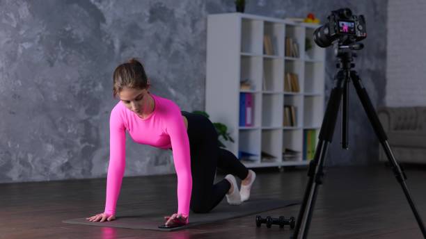 istock Athletic young lady in sportswear having workout while training at home, using smartphone and recording video on the camera. Home fitness, workout concept 1777894819