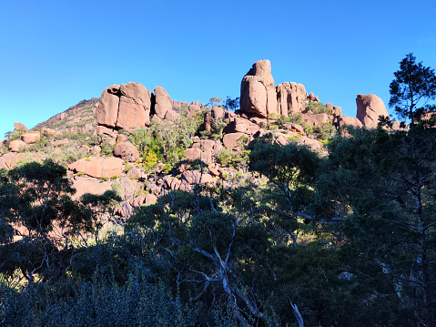 Red and pink granite formations on the Hazards, a series of jagged granite peaks in Freycinet Peninsula, an outcrop of wild, pristine coast land on Tasmania's east coast. It is part of Freycinet National Park.