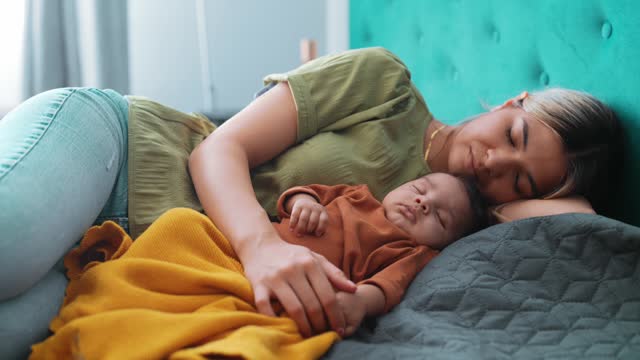 Young mother and baby napping at home