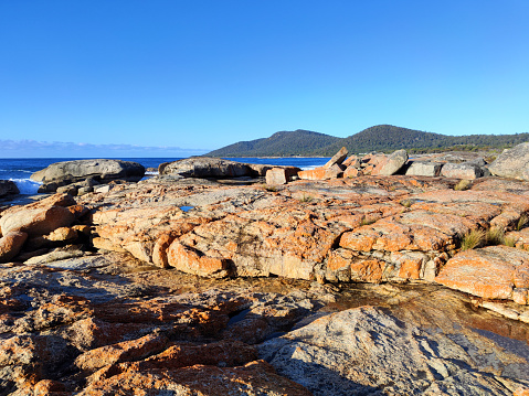 The red rocks on the coast in Bicheno, a small town in Tasmania, Australia.