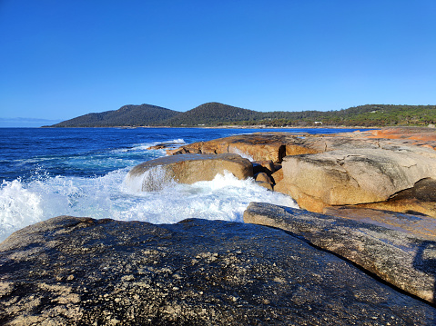 Waves crushing on the Rocky coastline in Bicheno, a small town in Tasmania, Australia.