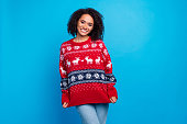 Photo of young funny woman showing her big ugly red sweater with reindeers print happy new year symbol isolated on blue color background