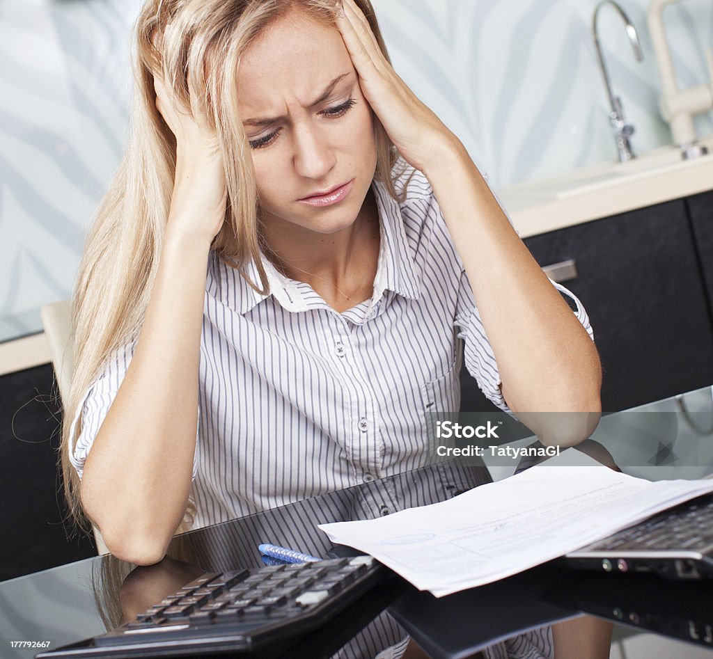 Sad woman looks at the bill Sad woman looks at the bill. Female working at home. Child Makes moms work 25-29 Years Stock Photo