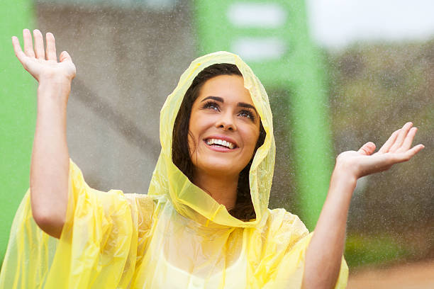 felice giovane donna gioca con la pioggia - poncho foto e immagini stock