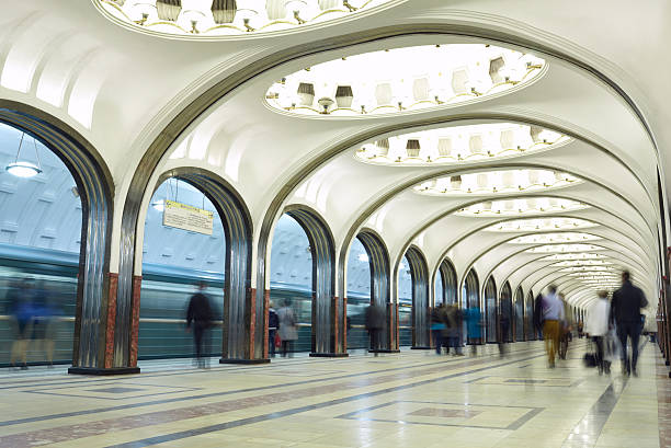 Motion blurred commuters at the metro station. Mayakovskaya station in Moscow underground. Beautiful arch architecture. Long exposure tripod shot with no visible faces.