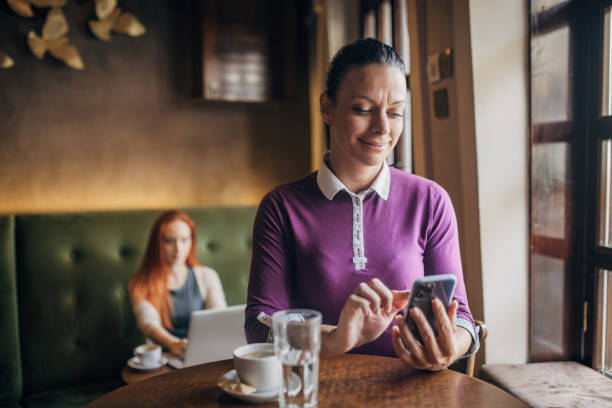 istock Woman using mobile phone while drinking coffee in the coffee shop 1777936984