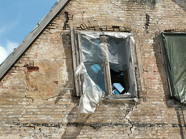 broken window at old building, tattered remnant of the plastic sheeting