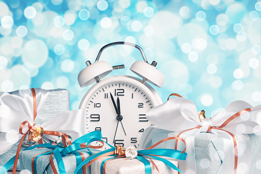 Beautifully wrapped gifts and the clock shows almost twelve o'clock. New Year celebration.