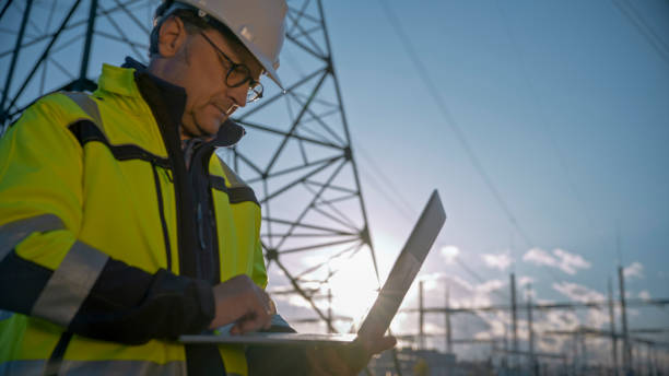 istock Mature Male Electrical Engineer Using Laptop At Power Station Against Sky During Sunny Day 1777961261