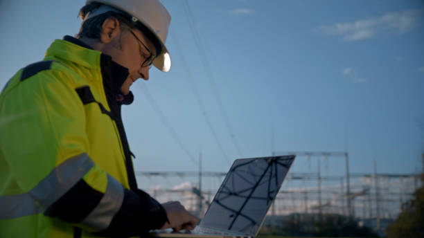 istock Side View Of Male Electrical Engineer Using Laptop At Power Station Against Blue Sky 1777961267