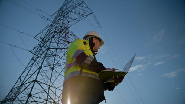istock Low Angle View Of Male Electrical Engineer Looking Away While Holding Laptop Against Blue Sky 1777961362