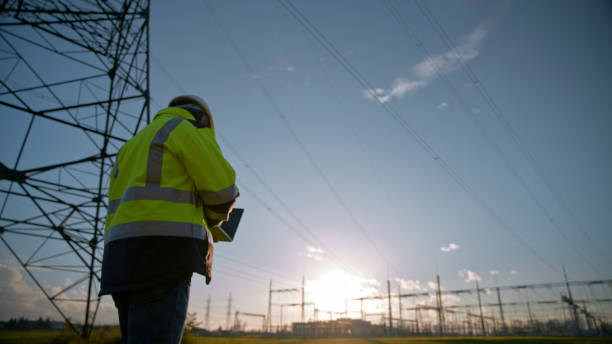 istock Low Angle View Of Male Electrical Engineer Using Laptop Against Blue Sky During Sunset 1777961803