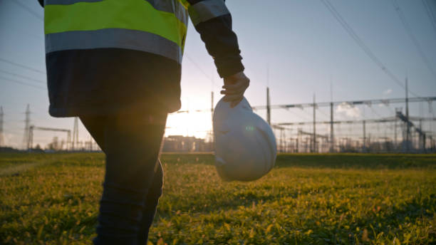 istock Midsection Of Female Engineer Holding Hardhat While Walking On Grassy Field At Power Station 1777961922