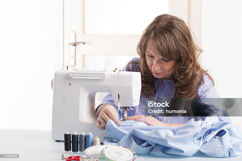 Femme à l'aide de la machine à coudre - Photo de Adulte libre de droits